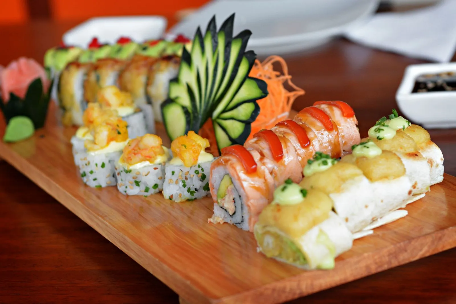Colorful sushi platter featuring various rolls with decorative garnishes, showcasing culinary art.